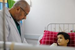 El doctor Khalil al-Duqran atiende a un niño con dos brazos malheridos en el hospital Al-Aqsa.