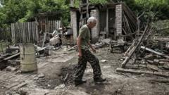 A man walks through the yard of a damaged house after shelling in which two people were killed in the city of Lysychansk in the eastern Ukrainian region of Donbas on June 13, 2022,