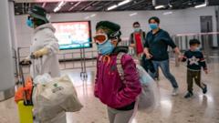 A girl wearing ski goggles and protective mask exits the arrival hall at Hong Kong High Speed Rail Station