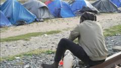 A man sits near tents in one of the Calais camps