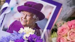 伦敦白金汉宫外悼念花堆中的一张英国女王伊丽莎白二世肖像（11/9/2022）