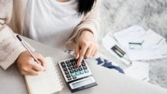 Mulher fazendo contas com calculadora