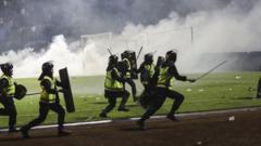 Police officers run as they try to stop football fans from entering the pitch