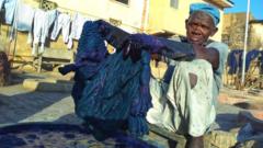 Local dyer Baba Muhammed dips cloth into dye bit in Kano