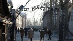 People walking through the infamous gate at Auschwitz, reading Arbeit Macht Frei - or work sets you free. File photo