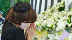 Женщина возложила цветы к мемориалу Абэ