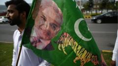 A supporter of Pakistan Muslim League-N (PML-N) holds a party flag with an image of Shehbaz Sharif outside the parliament house building in Islamabad on April 11, 2022.