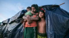 A Rohingya refugee family stands by their makeshift home in Bangladesh