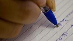 Pessoa escrevendo com caneta em papel