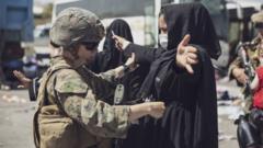 在哈米德卡爾扎伊國際機場，一名美國海軍陸戰隊員在撤離控制中心檢查一名婦女。