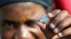 A South African holds up a gem stone, which turns out to be quartz