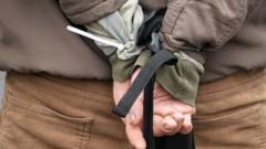 Detail of the tied hands of a suspected Russian collaborator detained by Kyiv territorial defence troops released on 3 March