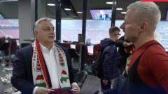 El primer ministro nacionalista húngaro, Viktor Orban, llega una bufanda de fútbol adornada con un mapa de una Hungría ampliada.
