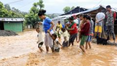 Residents wade through flood water in Dili, East Timor