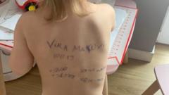 한 우크라이나 아이의 등에 이름과 출생일, 가족 연락처가 적혀있다