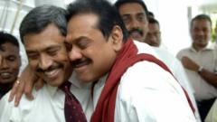 Colombo, SRI LANKA: Sri Lankan Defence Ministry Secretary Gotabaya Rajapakse (L) is hugged by elder brother Sri Lankan President Mahinda Rajapakse (C) in Colombo, 01 December 2006, after narrowly escaping assassination in a suicide bomb attack in the Sri Lankan capital. A suspected Tamil suicide bomber attacked a defence ministry convoy carrying the president's brother, killing at least one soldier, police said. Gotabaye Rajapakse, secretary to the defence ministry and brother of President Mahinda Rajapakse, was unhurt after the blast in the heart of the Sri Lankan capital.