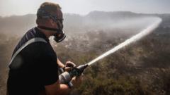 A firefighter tackles the wildfire on Saddleworth Moor which continues to spread after the blaze was declared a major incident by Greater Manchester Police.