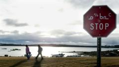 Two Inuit children return from school past a stop sign written in English and Inuit October 2002 in Iqaluit