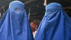 Afghan burqa-clad women are pictured at a market in Kabul on 20 December