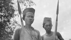 Dua pemuda Indonesia membawa bambu runcing (1947).