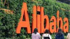 Four women walk past an Alibaba sign.
