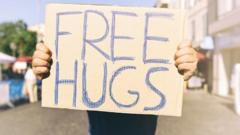 Person holds up free hugs sign