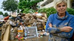 A resident in the Rhineland-Palatinate district of Ahrweiler stands in front of her property destroyed by a flood on 16 July 2021