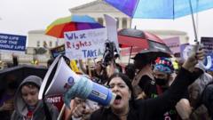 An anti-abortion activist (Front) shouts through a megaphone in front of abortion rights activists behind at the Supreme Court