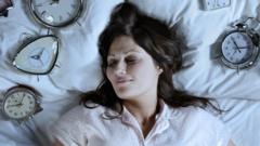 Una mujer durmiendo con relojes sobre la almohada