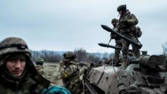 Servicemen of the Carpathian Sich Battalion are seen near an Armoured Personnel Carrier (APC) on a frontline