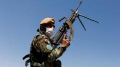 An Afghan National Army soldier holds a machine gun at a checkpoint on the outskirts of Kabul