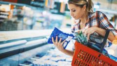 Woman looks at bag of frozen food