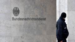 A policeman stands guard next to the logo and name of the Germany intelligence service, BND