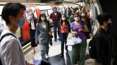 People wear protective face masks walk along a platform on the London Underground,