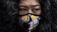 A Chinese woman wears a protective mask as she shops in a market on 6 February, 2020 in Beijing, China