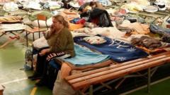 Refugees sleep in a hall strewn with beds and makeshift blankets in a town in eastern Poland