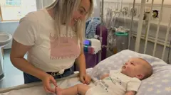 Samantha Williams Samantha Williams and her young son Lucian Neal in a hospital room. Lucien is lying on the bed, his body and head resting on a large pillow. He is looking at his mother, Samantha, who has blonde hair and is smiling at him.