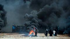 Palestinians burn tyres as they clash with Israeli forces near the border between the Gaza strip and Israel
