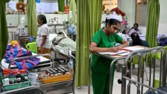 A ward at the District General Hospital in Sri Lanka's Negombo city where dengue patients are getting treated. A nurse in green is seen taking notes in the foreground