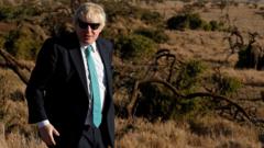 Boris Johnson watches elephants graze at the Lewa wildlife conservancy, sprawling over the Laikipia plains, in northern Kenya, on March 17, 2017