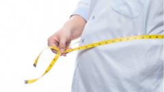 Homem com obesidade medindo cintura com a fita métrica