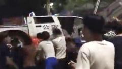 Footage of people protesting with a car in the background