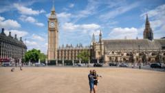 A couple pose for a selfie on the dried-up grass in Parliament Square, in Westminster, London