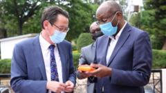 Amb Richard Masozera (iburyo) ashyikiijwe na Ambasaderi w'Ububiligi i Kigali hard disk iriho amajwi yafatiwe mu Rwanda