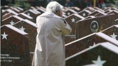 An elderly Russian woman cries while visiting a military cemetary in Moscow where numerous veterans of WWII are buried