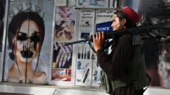 A Taliban fighter walks past a beauty salon with images of women defaced using spray paint in Shar-e-Naw in Kabul on August 18, 2021.