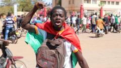 A teenager reacts as he shows support for the military after Burkina Faso President Roch Kaboré was detained at a military camp in Ouagadougou, Burkina Faso, on 24 January 2022