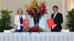 Bộ trưởng thương mại Anh, bà Lizz Truss và người tương nhiệm Singapore Chan Chun Sing tại lễ ký FTA ở Singapore hôm 10/12