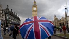 Pessoa segura guarda-chuva com bandeira do Reino Unido em frente ao Big Ben