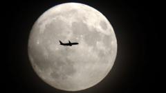 A commercial jet flies in front of the moon on its approach to Heathrow airport in west London on November 13, 2016.
